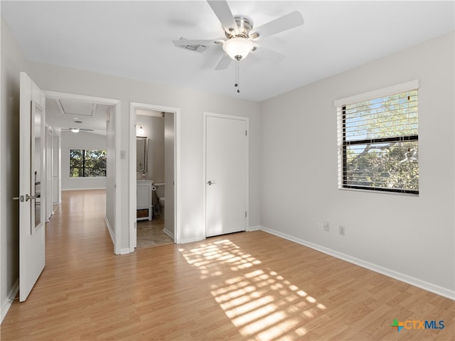 unfurnished bedroom featuring connected bathroom and light hardwood / wood-style floors