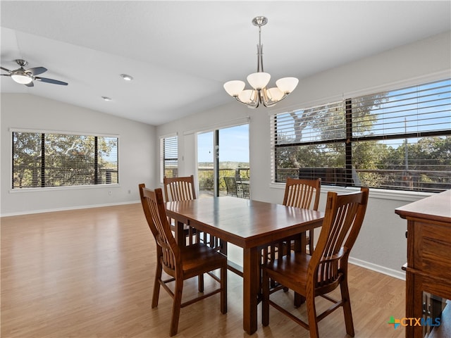 dining room with vaulted ceiling, ceiling fan with notable chandelier, and light hardwood / wood-style floors