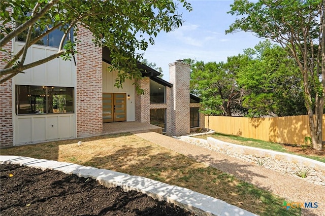 910 Cliffside Dr, Harker Heights, TX 76548 - back of property with a chimney, brick siding, board and batten siding, and french doors