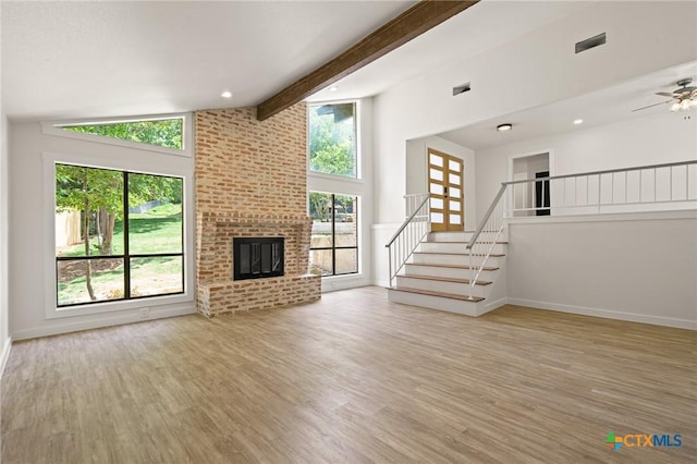 910 Cliffside Dr, Harker Heights, TX 76548 - unfurnished living room with plenty of natural light, stairs, beam ceiling, wood finished floors, and high vaulted ceiling