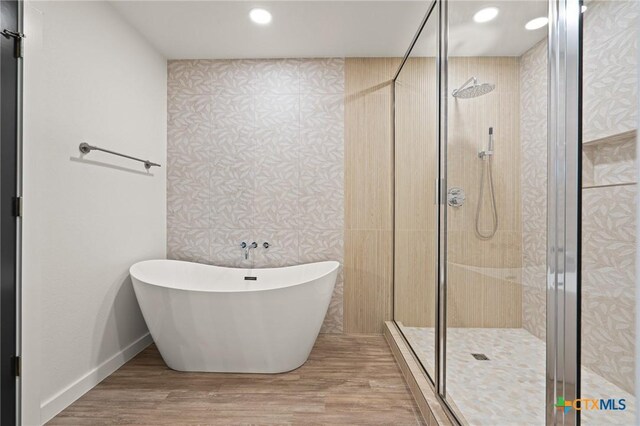 910 Cliffside Dr, Harker Heights, TX 76548 - bathroom with a freestanding bath, a stall shower, wallpapered walls, wood finished floors, and baseboards
