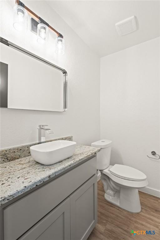 910 Cliffside Dr, Harker Heights, TX 76548 - bathroom with vanity, wood finished floors, toilet, and baseboards