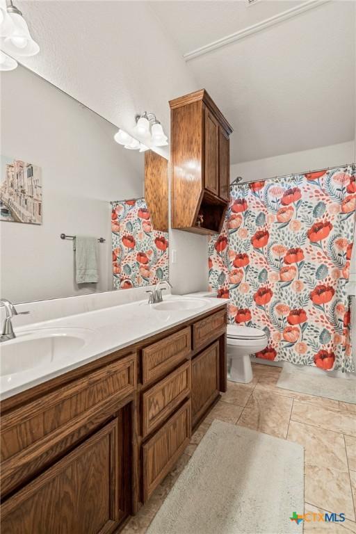 bathroom featuring vanity, toilet, and tile patterned flooring