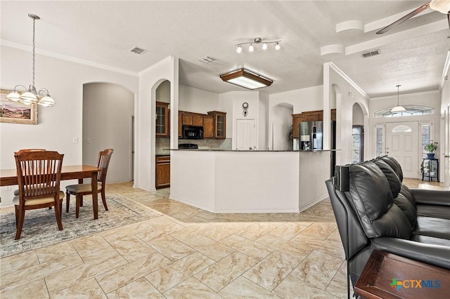 kitchen featuring pendant lighting, tasteful backsplash, stainless steel fridge, ornamental molding, and a textured ceiling