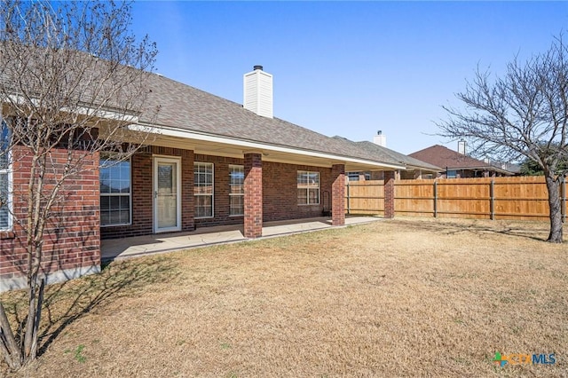 rear view of property with a yard and a patio