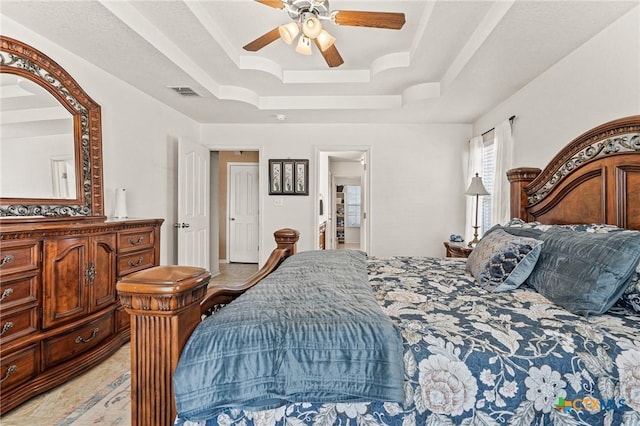 bedroom featuring a raised ceiling and ceiling fan