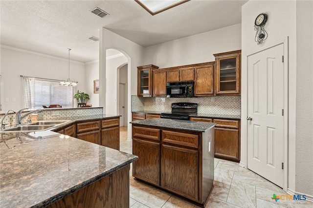 kitchen with sink, tasteful backsplash, decorative light fixtures, a kitchen island, and black appliances