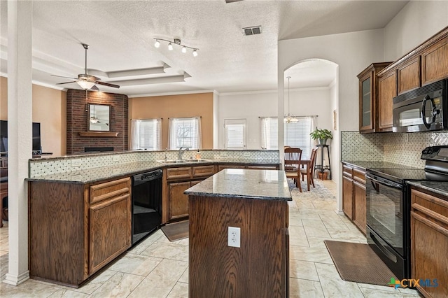 kitchen featuring a center island, sink, dark stone counters, and black appliances