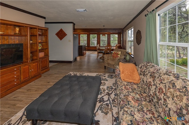 living room featuring hardwood / wood-style floors, a wealth of natural light, and ornamental molding