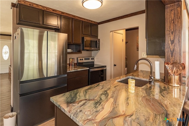 kitchen featuring dark brown cabinetry, crown molding, sink, and appliances with stainless steel finishes