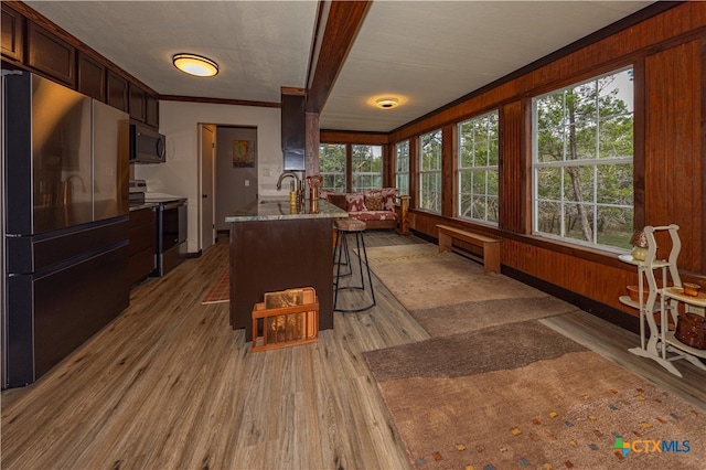 kitchen with stainless steel appliances, a healthy amount of sunlight, light hardwood / wood-style flooring, and crown molding