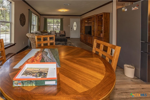 dining room featuring wood-type flooring and ornamental molding