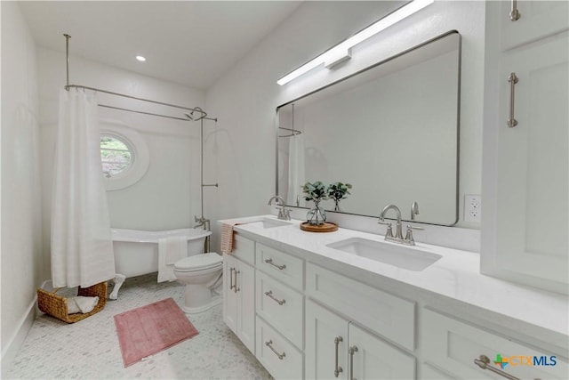 bathroom with toilet, double vanity, a sink, and a washtub