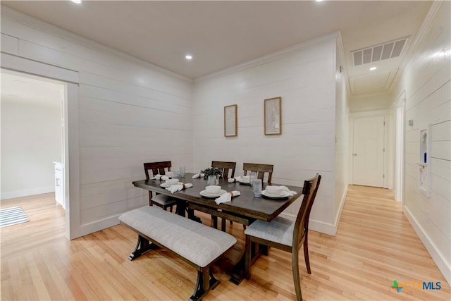 dining space with light wood-type flooring, baseboards, visible vents, and ornamental molding