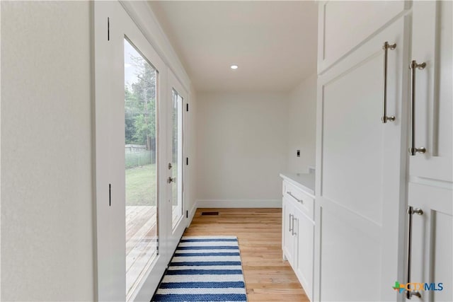 doorway with baseboards, recessed lighting, visible vents, and light wood-style floors