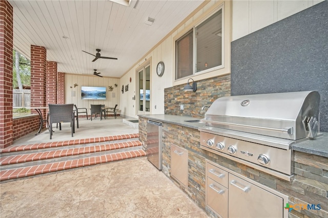 view of patio / terrace featuring a grill, ceiling fan, and exterior kitchen