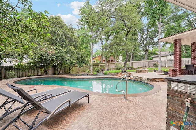 view of pool with a patio, a fenced in pool, a fenced backyard, and an outdoor fire pit