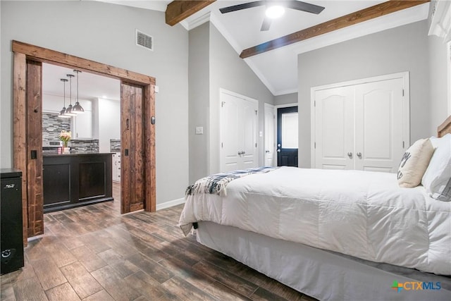 bedroom featuring baseboards, visible vents, a ceiling fan, lofted ceiling with beams, and wood finished floors