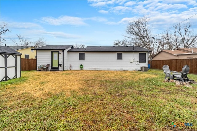 back of property with cooling unit, entry steps, a lawn, and fence private yard