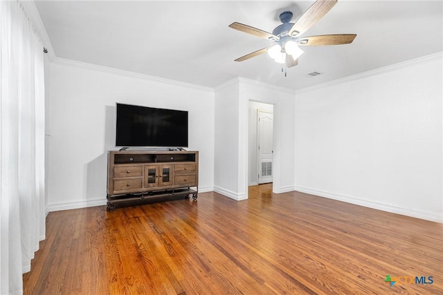 unfurnished living room with wood finished floors, visible vents, baseboards, a ceiling fan, and crown molding