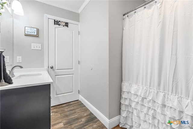 full bath with crown molding, curtained shower, vanity, wood finished floors, and baseboards