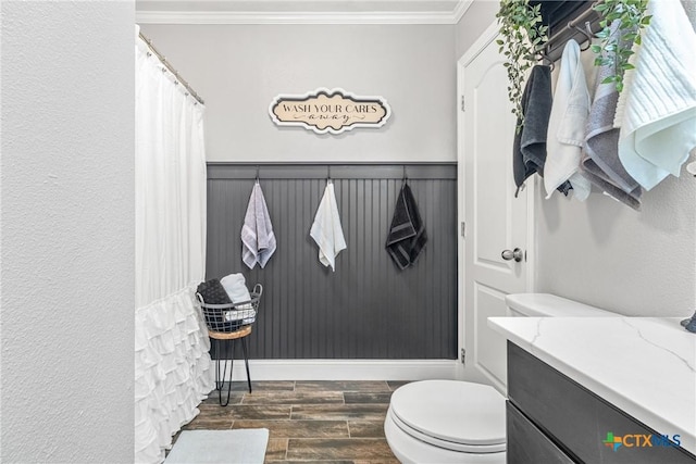 bathroom with a shower with shower curtain, toilet, ornamental molding, wood tiled floor, and vanity