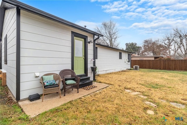 back of house with central AC, a lawn, and fence