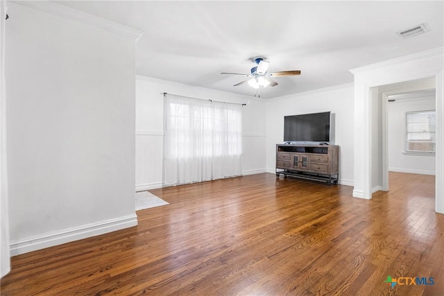 unfurnished living room with crown molding, visible vents, a ceiling fan, and wood finished floors