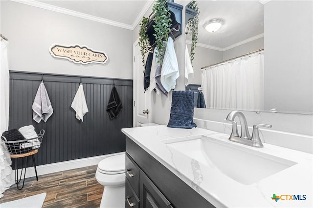 bathroom featuring ornamental molding, a wainscoted wall, vanity, and wood finished floors