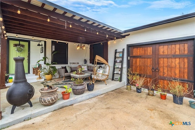 view of patio / terrace featuring a garage and outdoor lounge area