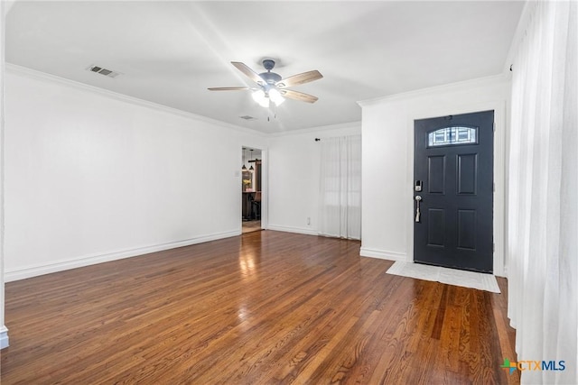 foyer with ceiling fan, ornamental molding, wood finished floors, and baseboards