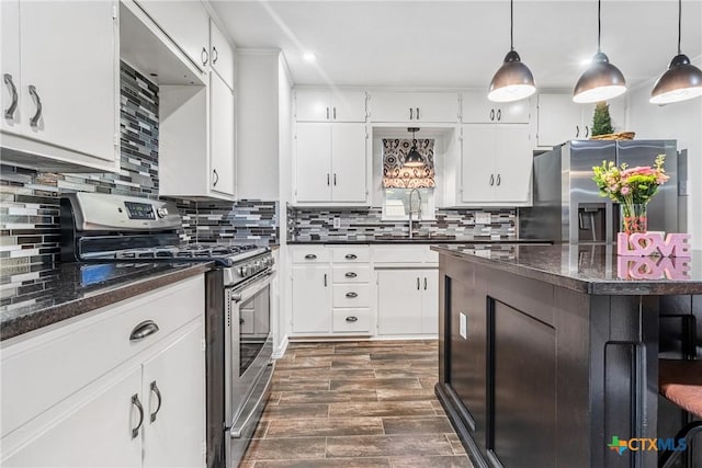 kitchen featuring stainless steel appliances, backsplash, dark wood-type flooring, white cabinets, and a sink