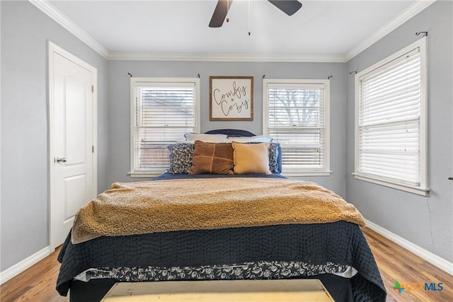 bedroom featuring a ceiling fan, baseboards, ornamental molding, and wood finished floors