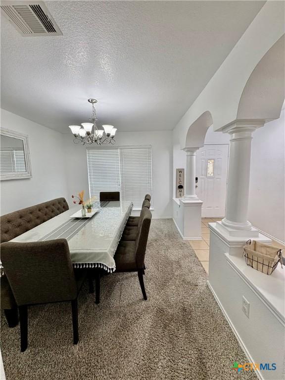 5902 Chuckwagon Cir, Killeen, TX 76542 - dining area featuring decorative columns, a chandelier, light carpet, and a textured ceiling