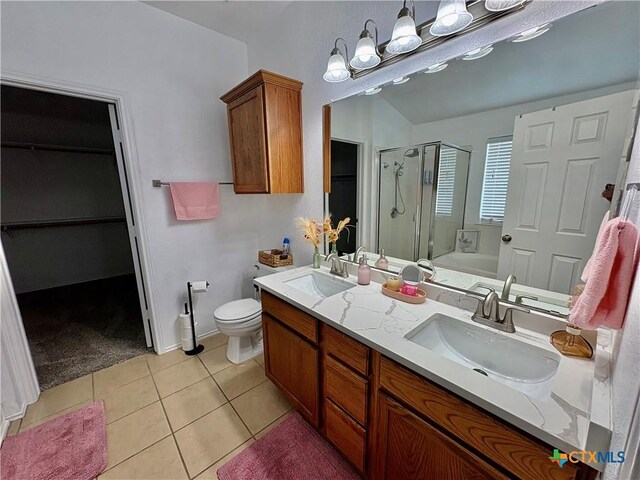 5902 Chuckwagon Cir, Killeen, TX 76542 - bathroom with a shower stall, a walk in closet, double vanity, tile patterned floors, and toilet