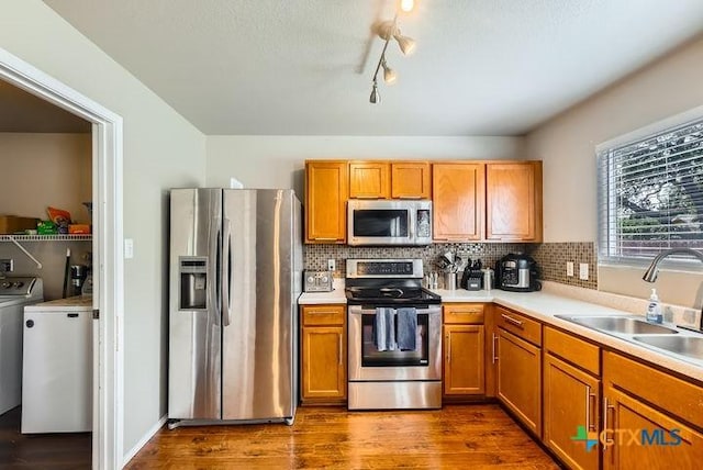 25923 Torch Lily, San Antonio, TX 78260 - kitchen with appliances with stainless steel finishes, washer and dryer, a sink, and brown cabinets