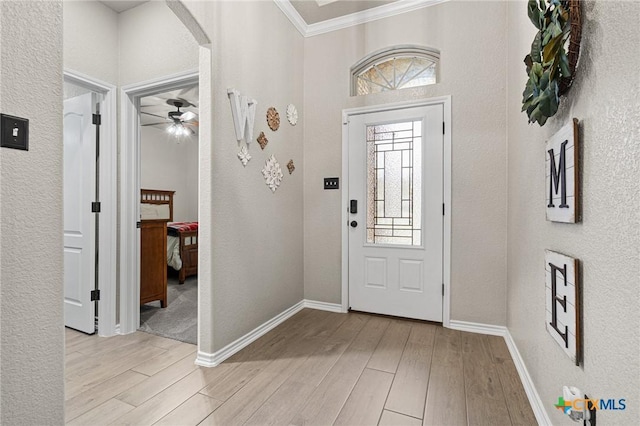 foyer with crown molding and light wood-type flooring