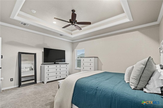 bedroom featuring ceiling fan, light carpet, and a tray ceiling