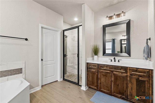 bathroom featuring hardwood / wood-style floors, vanity, and separate shower and tub