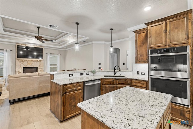 kitchen with a center island, crown molding, sink, appliances with stainless steel finishes, and decorative light fixtures