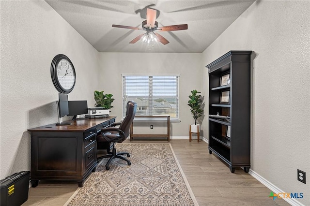 home office with ceiling fan, light wood-type flooring, and a textured ceiling