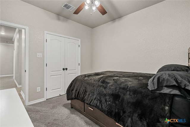 carpeted bedroom with ceiling fan and a closet