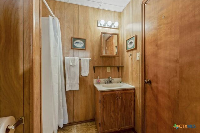 bathroom with vanity, a shower with curtain, and wooden walls