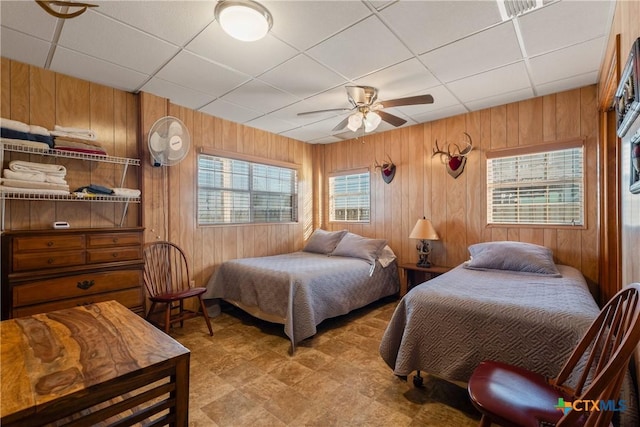 bedroom with wooden walls and multiple windows