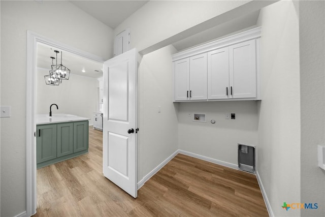 15938 Salado Dr, Temple, TX 76502 - laundry room featuring cabinet space, hookup for an electric dryer, hookup for a washing machine, and light wood-style floors