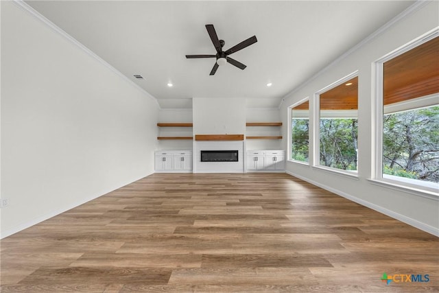 15938 Salado Dr, Temple, TX 76502 - unfurnished living room with ceiling fan, a glass covered fireplace, wood finished floors, recessed lighting, and ornamental molding