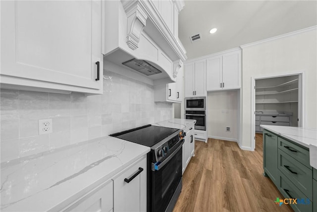 15938 Salado Dr, Temple, TX 76502 - kitchen with appliances with stainless steel finishes, white cabinetry, light wood-style floors, light stone counters, and recessed lighting