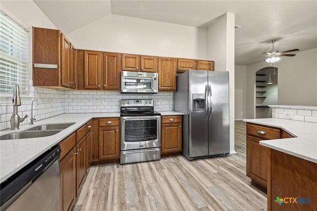 7617 Amber Meadow Loop, Temple, TX 76502 - kitchen featuring stainless steel appliances, a sink, tasteful backsplash, brown cabinetry, and lofted ceiling