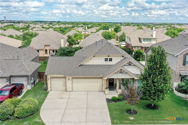 view of front of house with stone siding, an attached garage, a residential view, concrete driveway, and board and batten siding