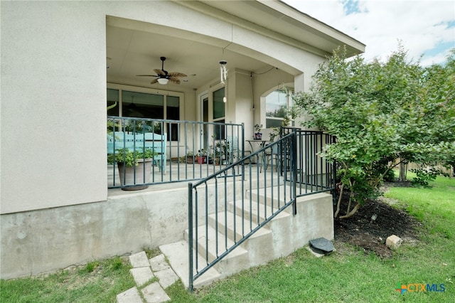 view of patio with ceiling fan and stairway